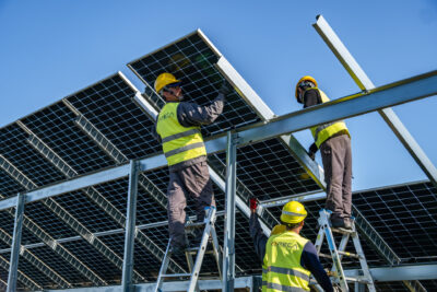 Mitarbeiter von Reca Solar montieren Module im Solarpark.